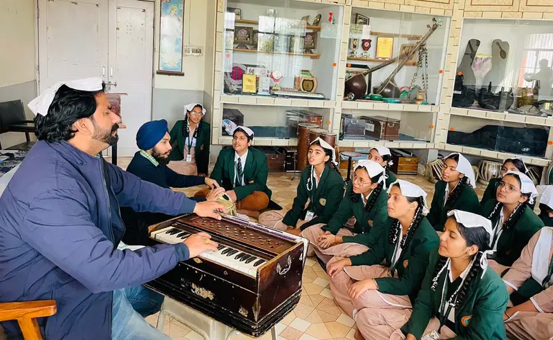 A student playing the harmonium in the music room