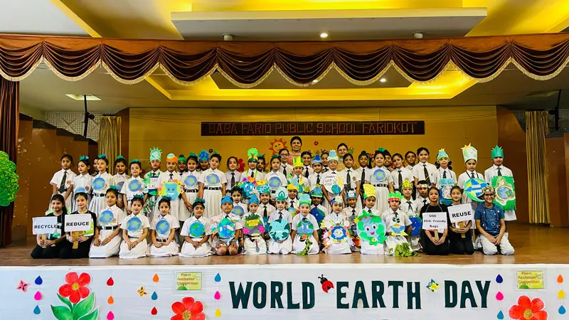 Students performing on the auditorium stage at a World Earth Day event
