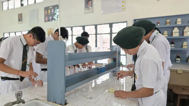 A teacher guiding students during a lab practical